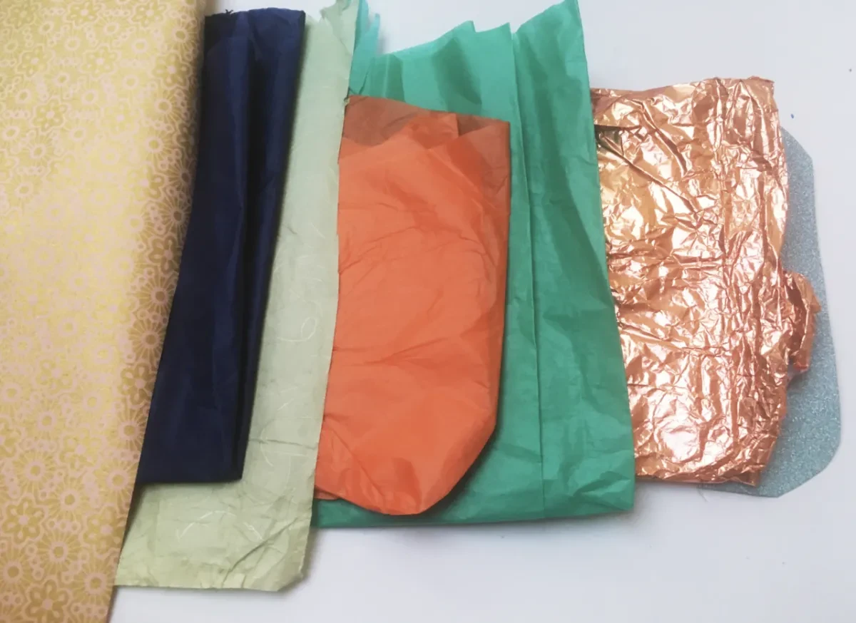 Scraps of coloured paper, including orange, green and shiny pieces