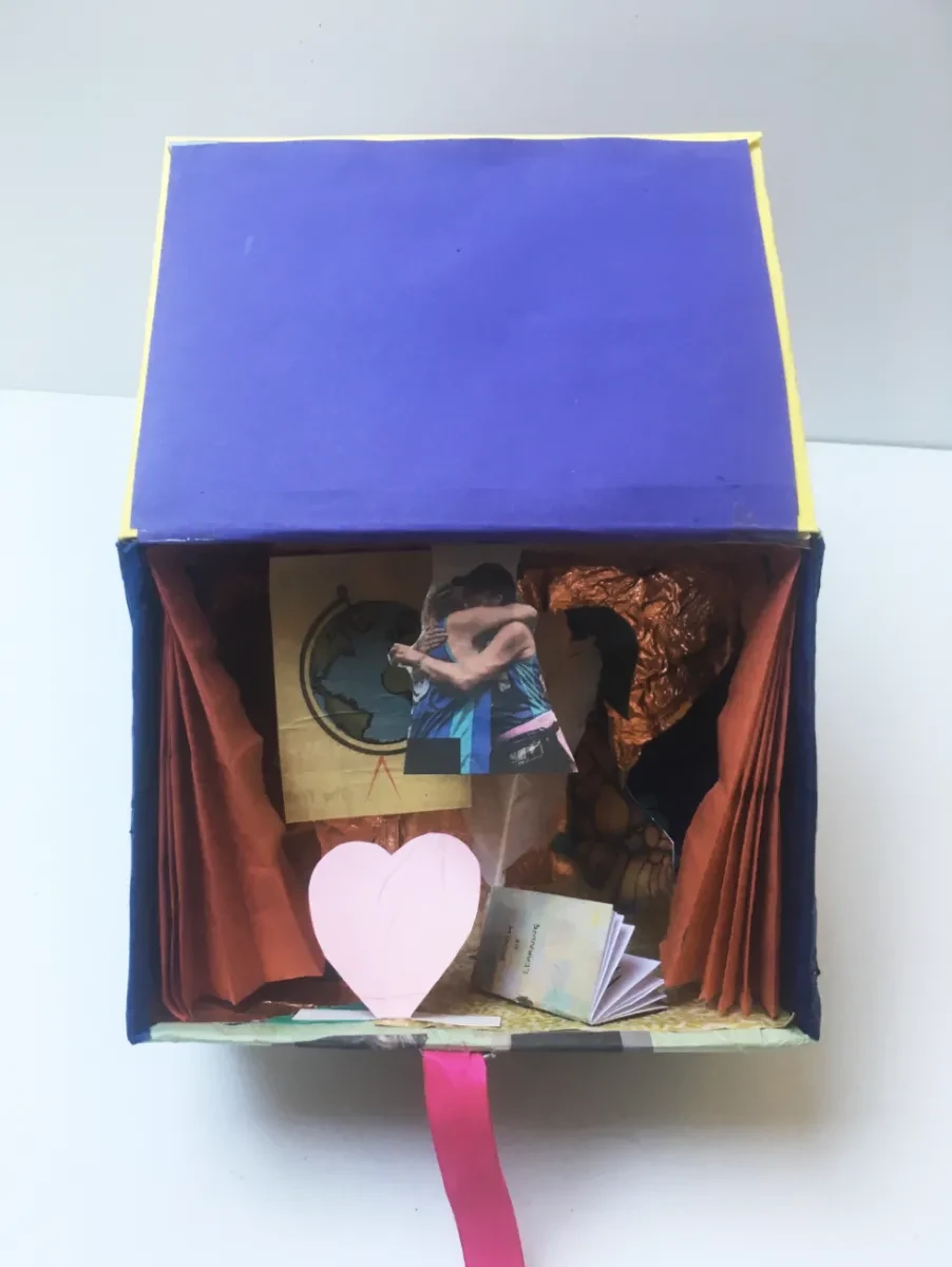 The inside of a personally decorated identity box, with photos and scraps of paper kept for safekeeping