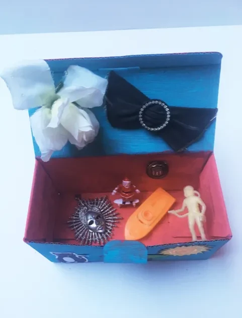 The inside of a personal memory box, with trinkets including a skateboarding Santa and bowtie