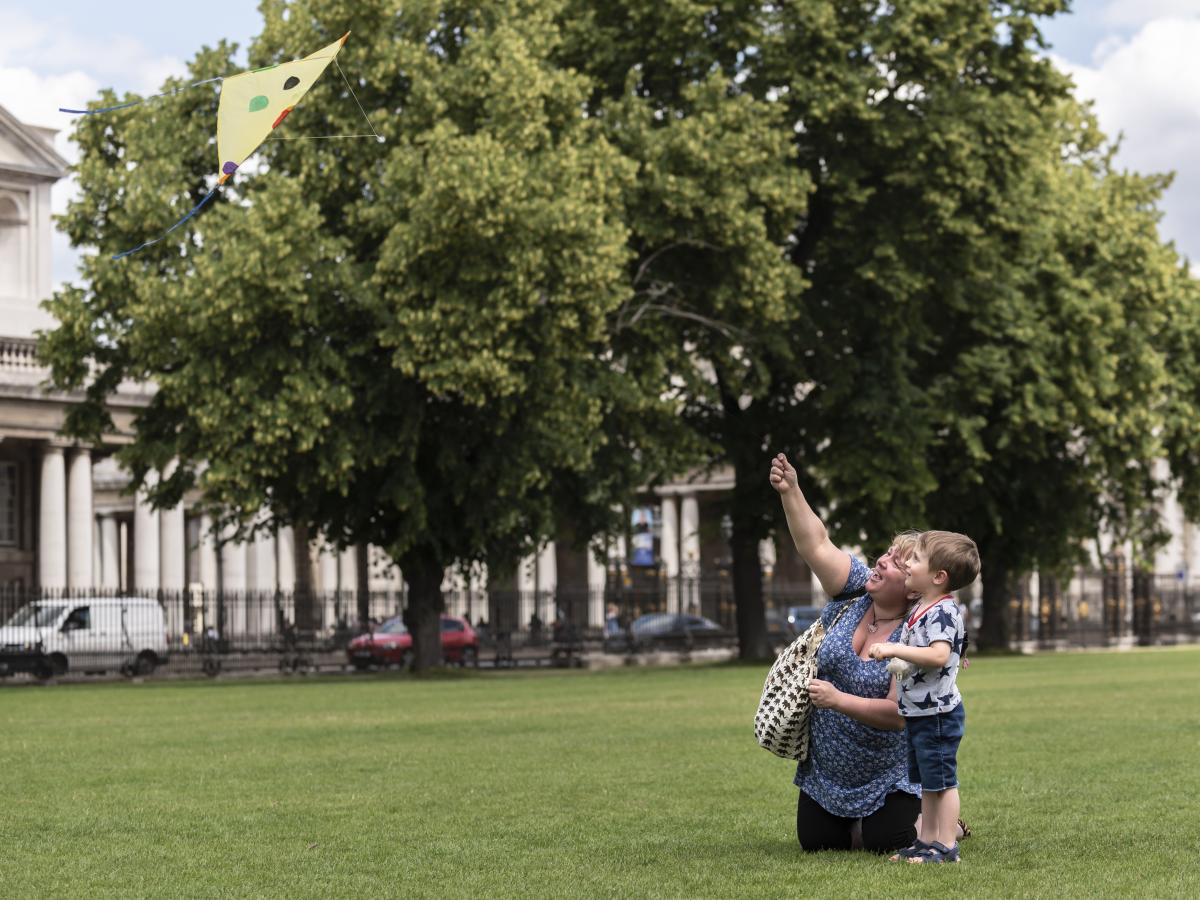 A parent and child fly a homemade kite outside the Museum.