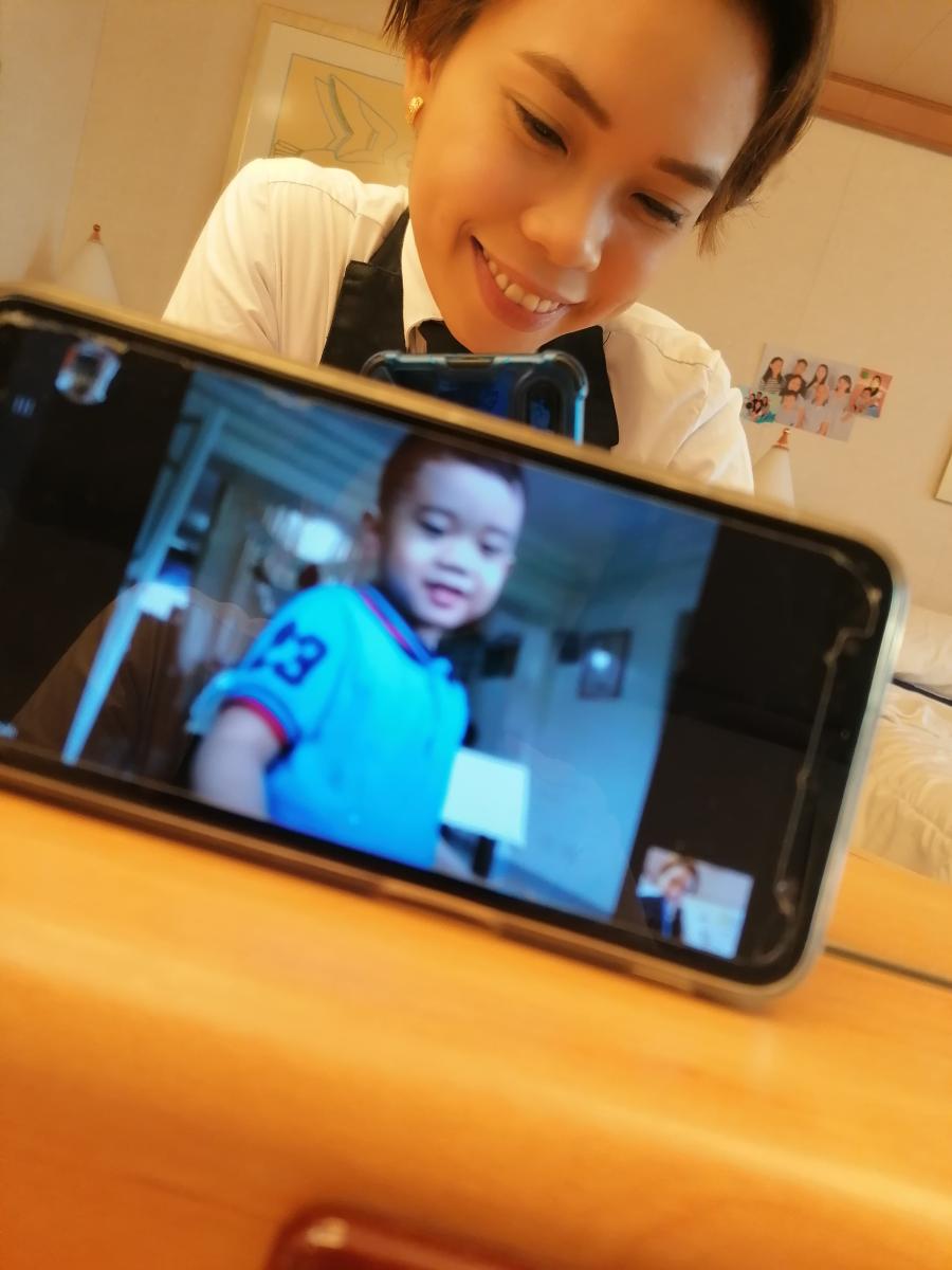 A woman takes a picture of a FaceTime call with her son