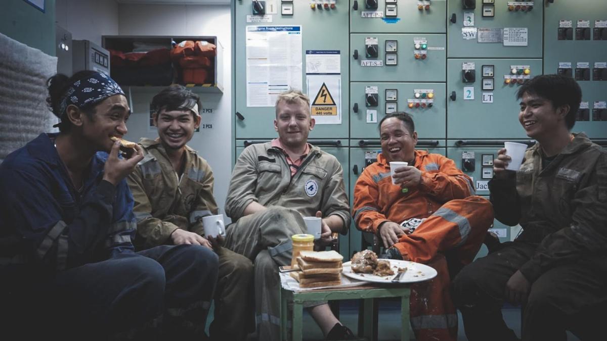 Group of sailors smile together on board ship