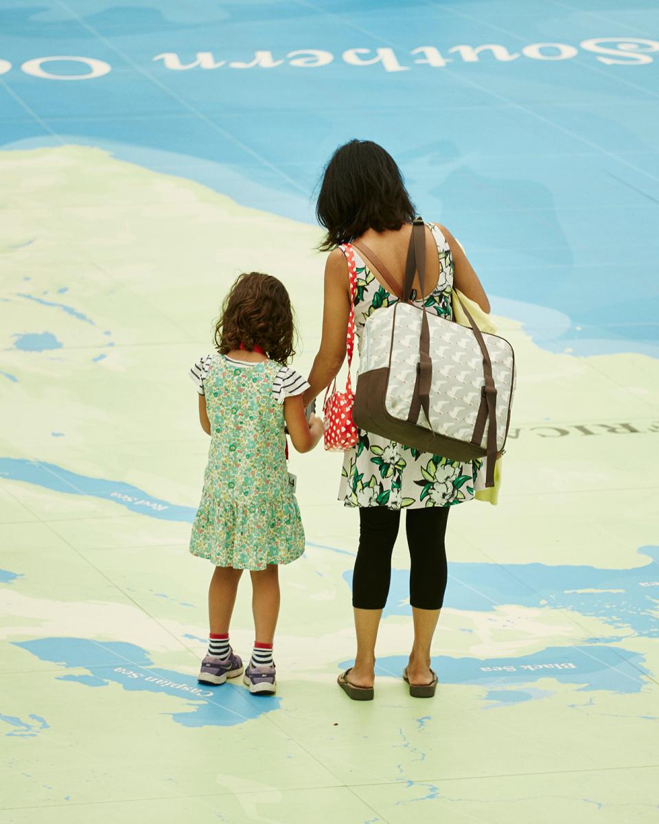 A mother and child walk across the Great Map, the giant world atlas at the National Maritime Museum