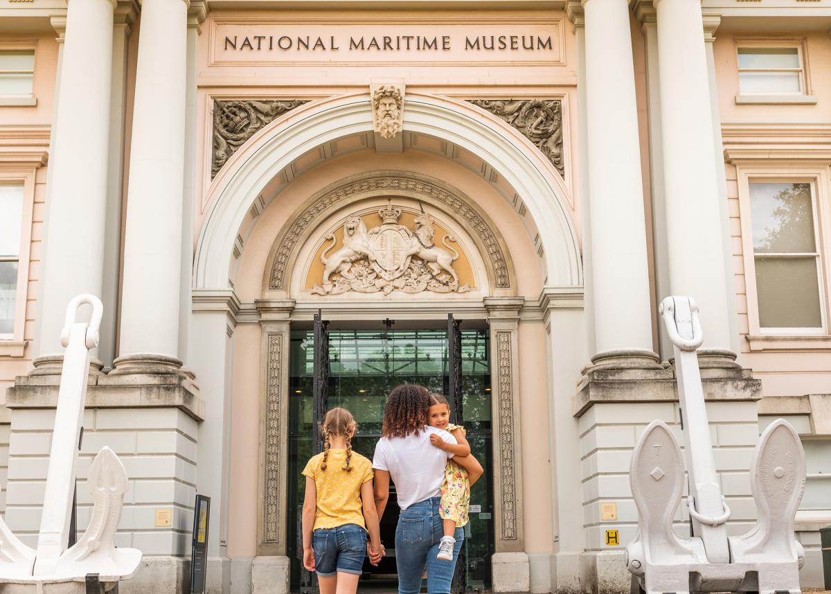 A family walks through the main entrance of the National Maritime Museum in Greenwich, London