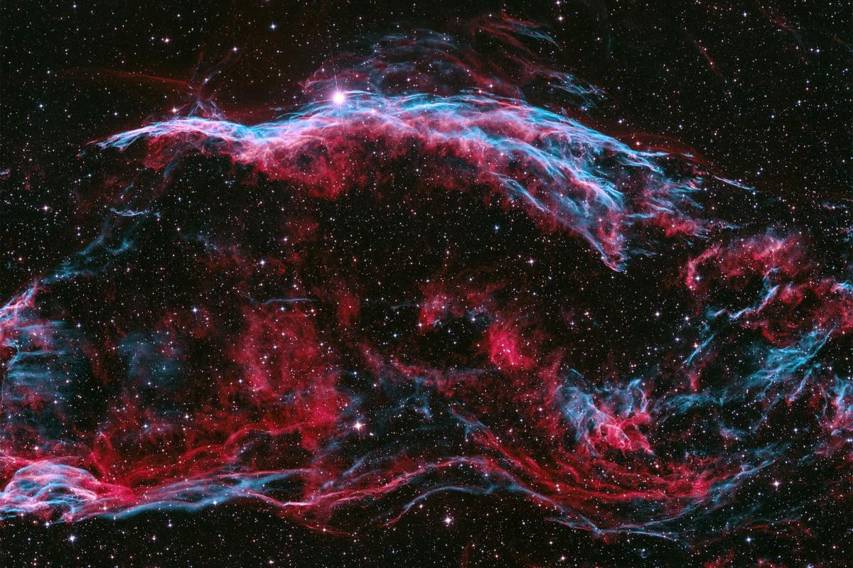 A rich purple space photograph showing the Veil Nebula