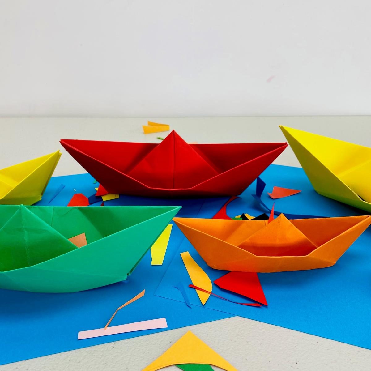Paper boats on blue paper