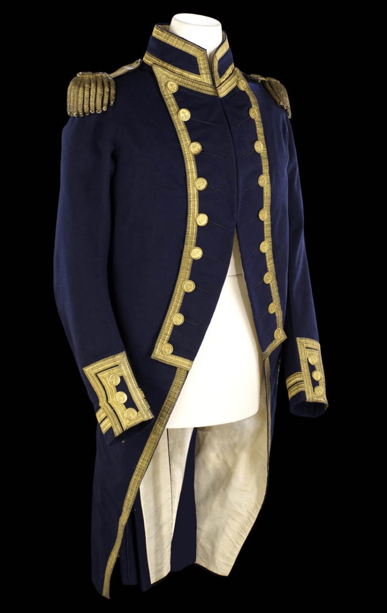 A Royal Navy captain's uniform from between 1795 and 1812. The tailored navy blue jacket features gold trim and cuffs