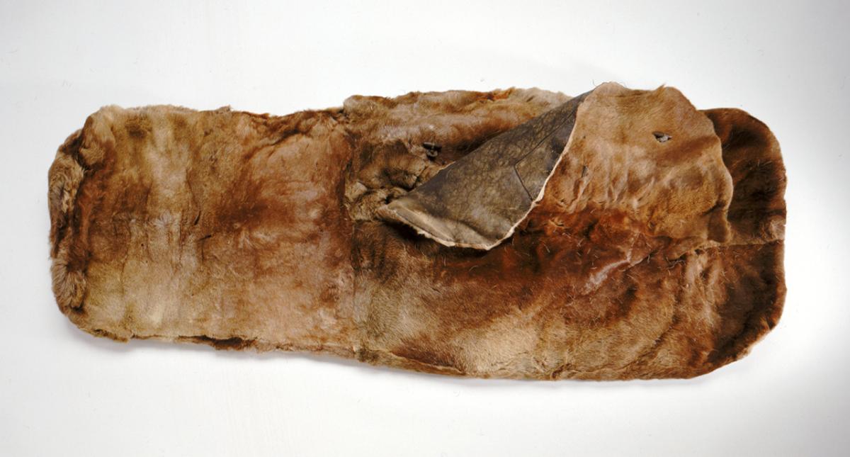 A sleeping bag from the 1900s made of sealskin. The bag is mottled brown and partially open