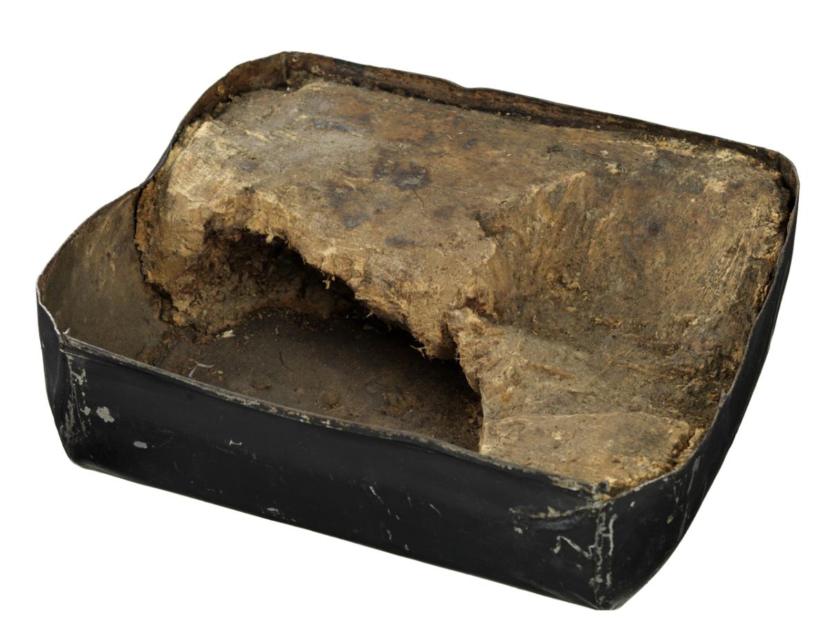 An old battered tin containing 'pemmican', a type of dried and pounded meat mixed with fat