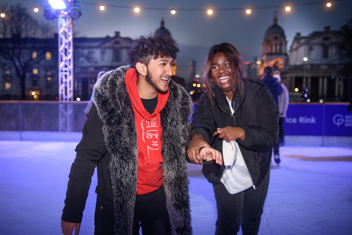 Two young people holding hands and smiling at the Queen's House Ice Rink