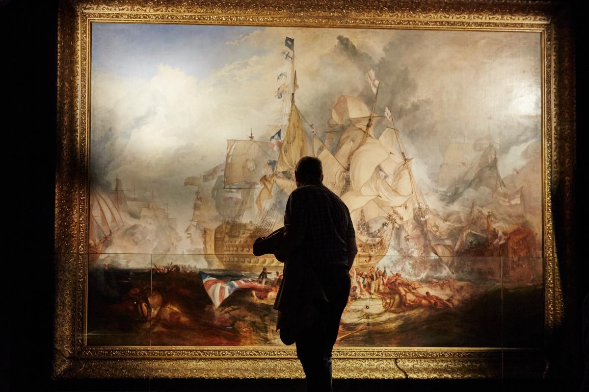 Person looking at the Battle of Trafalgar painting 