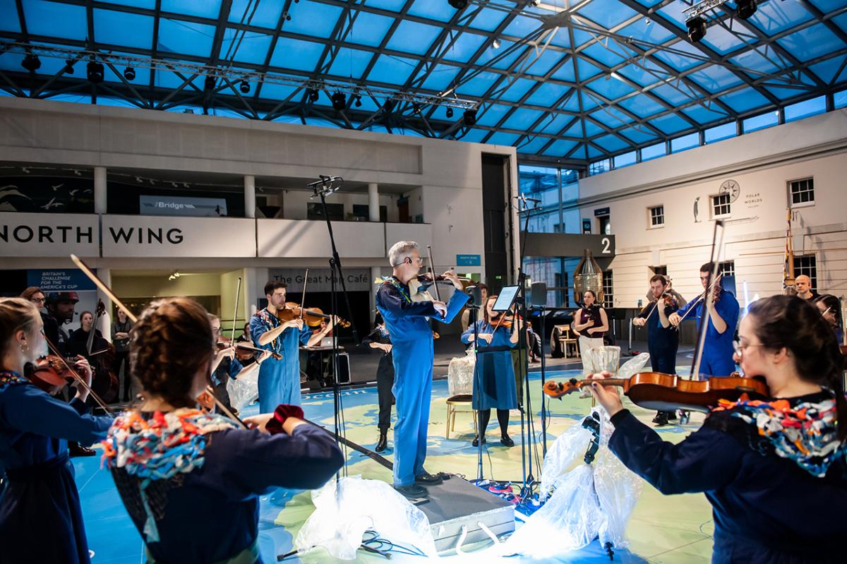A string ensemble performs beneath a glass roof on the Great Map of the National Maritime Museum