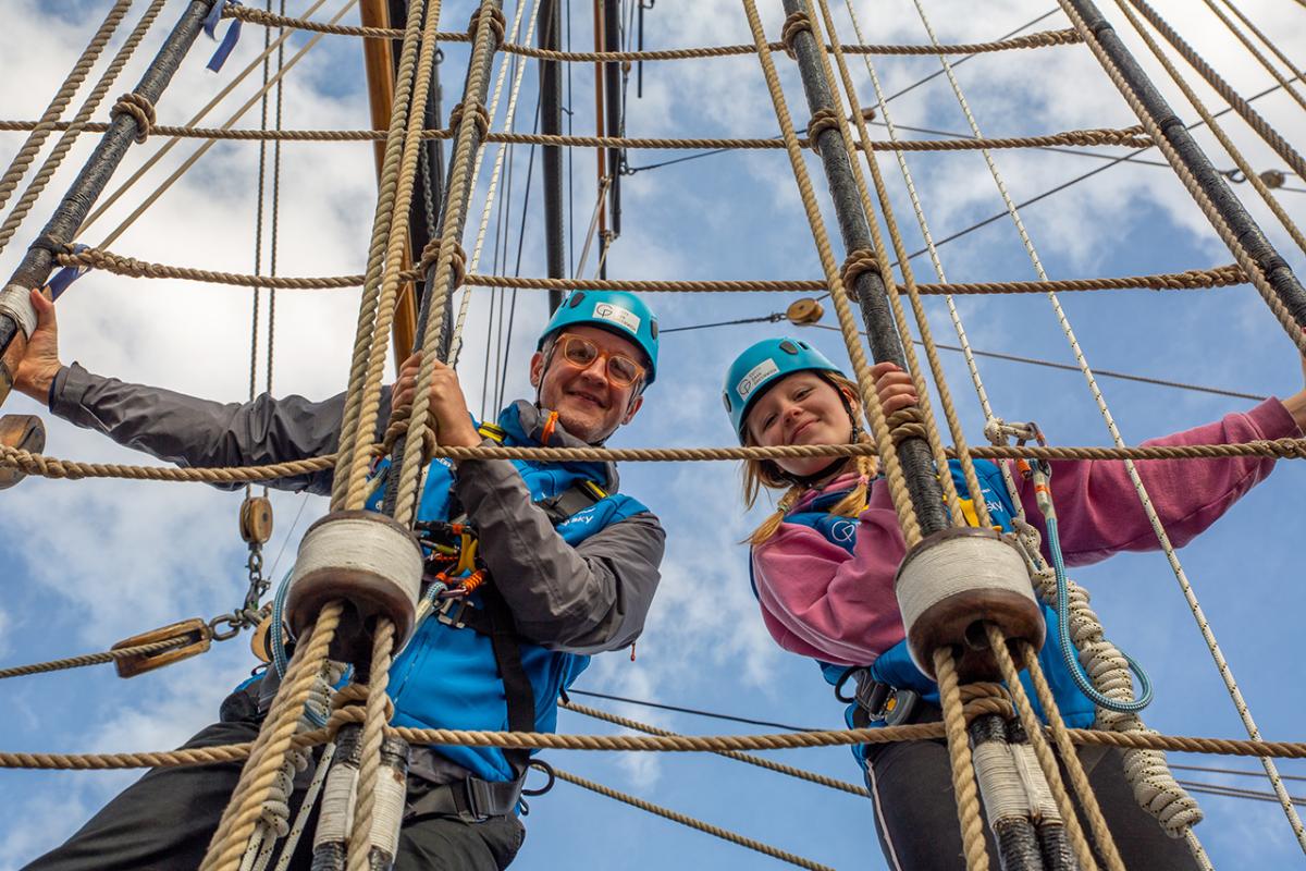 Two people climb the rigging of historic ship Cutty Sark