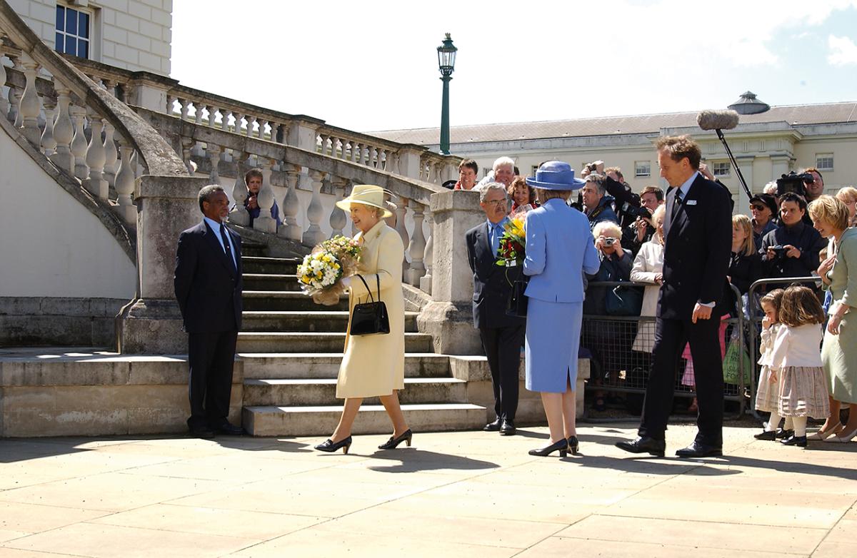 Her Majesty The Queen, carrying a bouquet of flowers and wearing a pale yellow outfit and matching hat, visiting the Queen's House in Greenwich in 2003