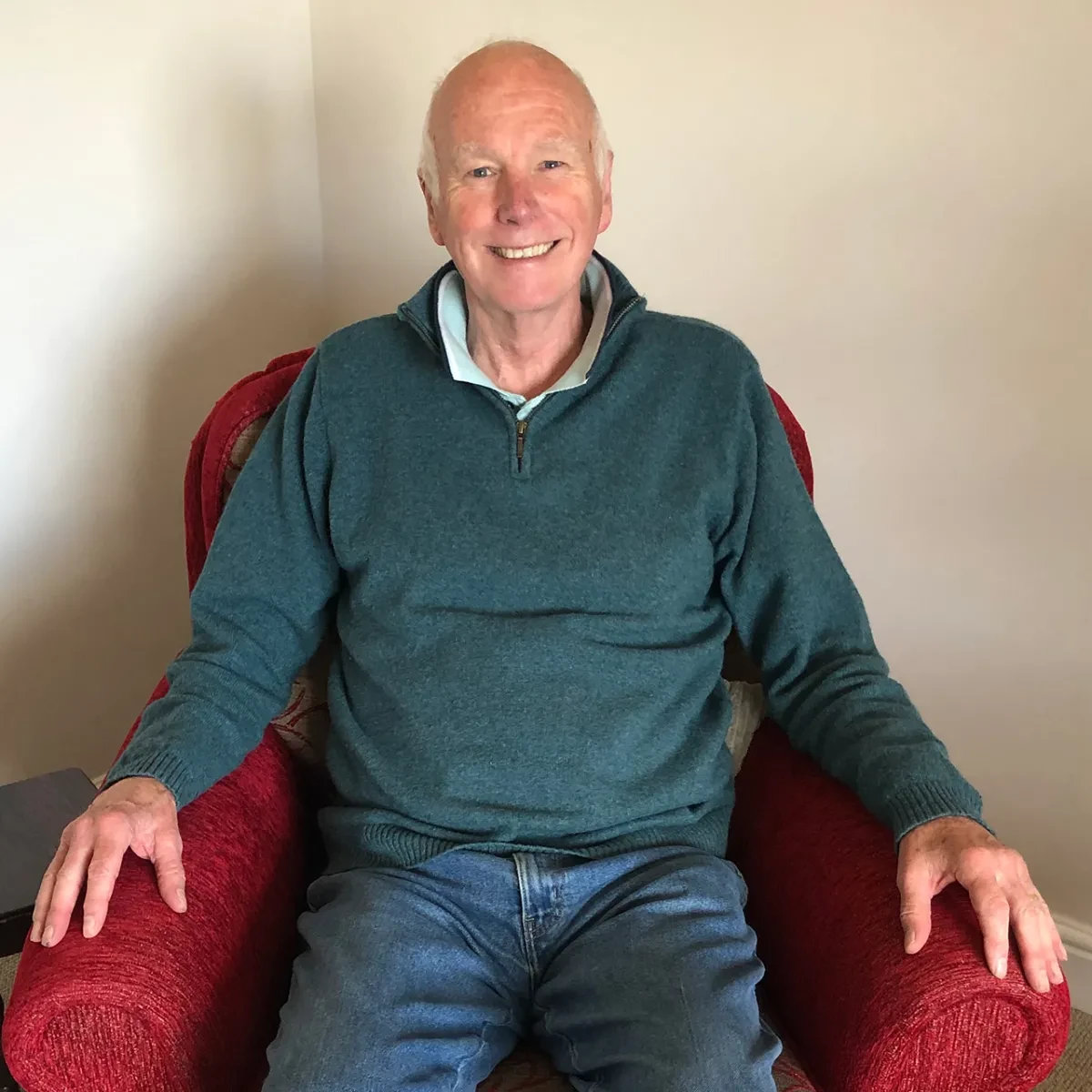 A photograph of Howard Ormerod, showing him sitting in an armchair smiling at the camera. He participated in a National Maritime Museum oral history project