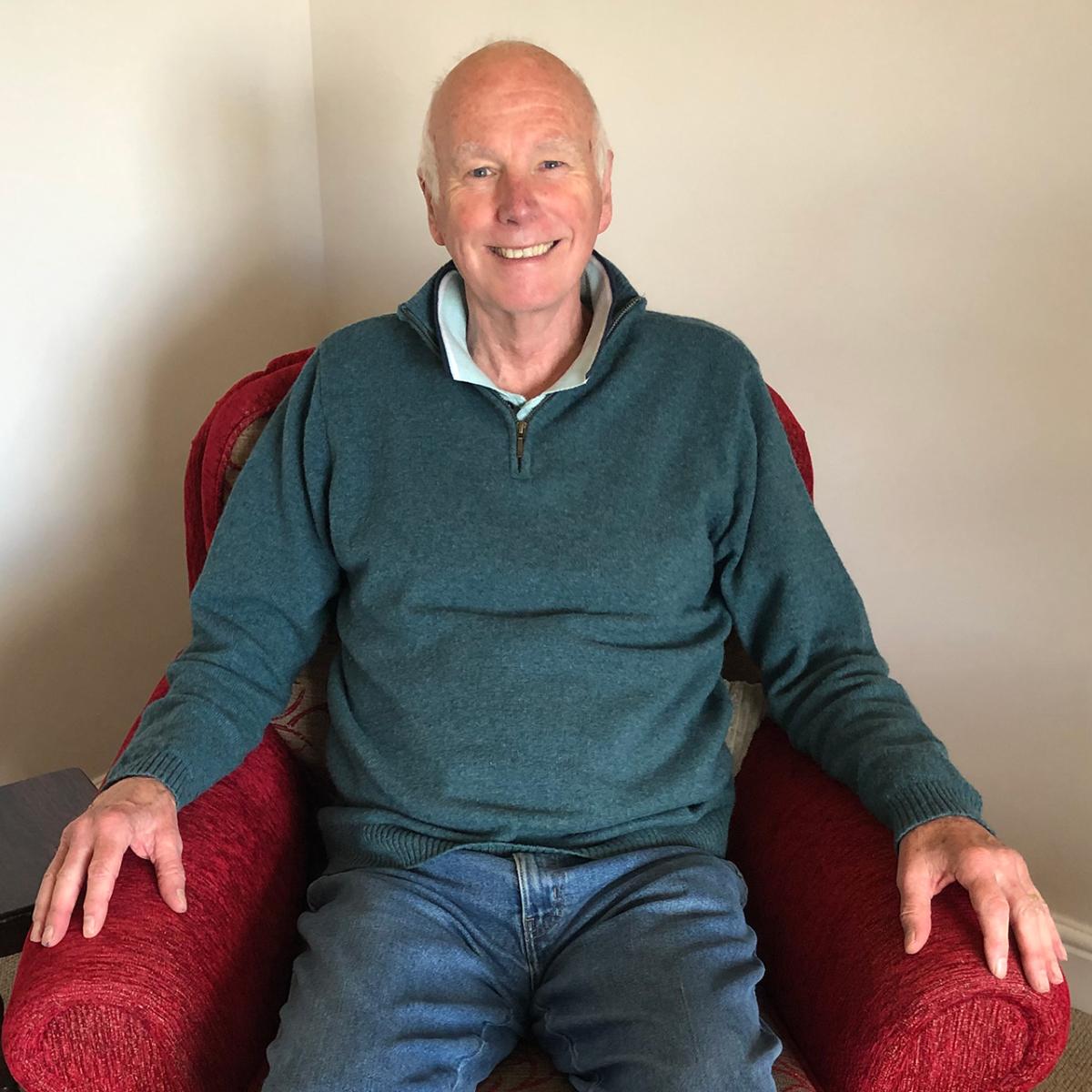 A photograph of Howard Ormerod, showing him sitting in an armchair smiling at the camera. He participated in a National Maritime Museum oral history project