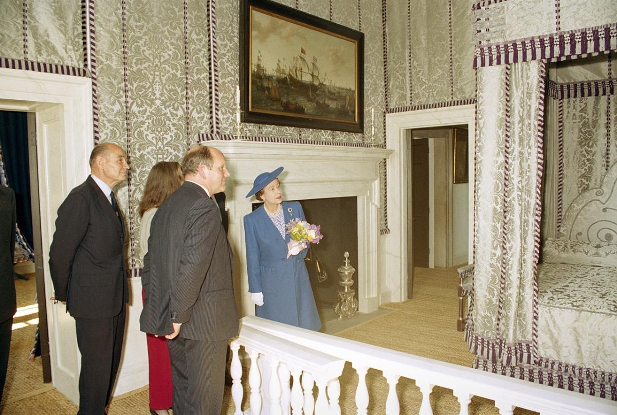 Elizabeth II looks at an ornate bed in a historic photograph of her visit to the Queen's House in Greenwich in 1990