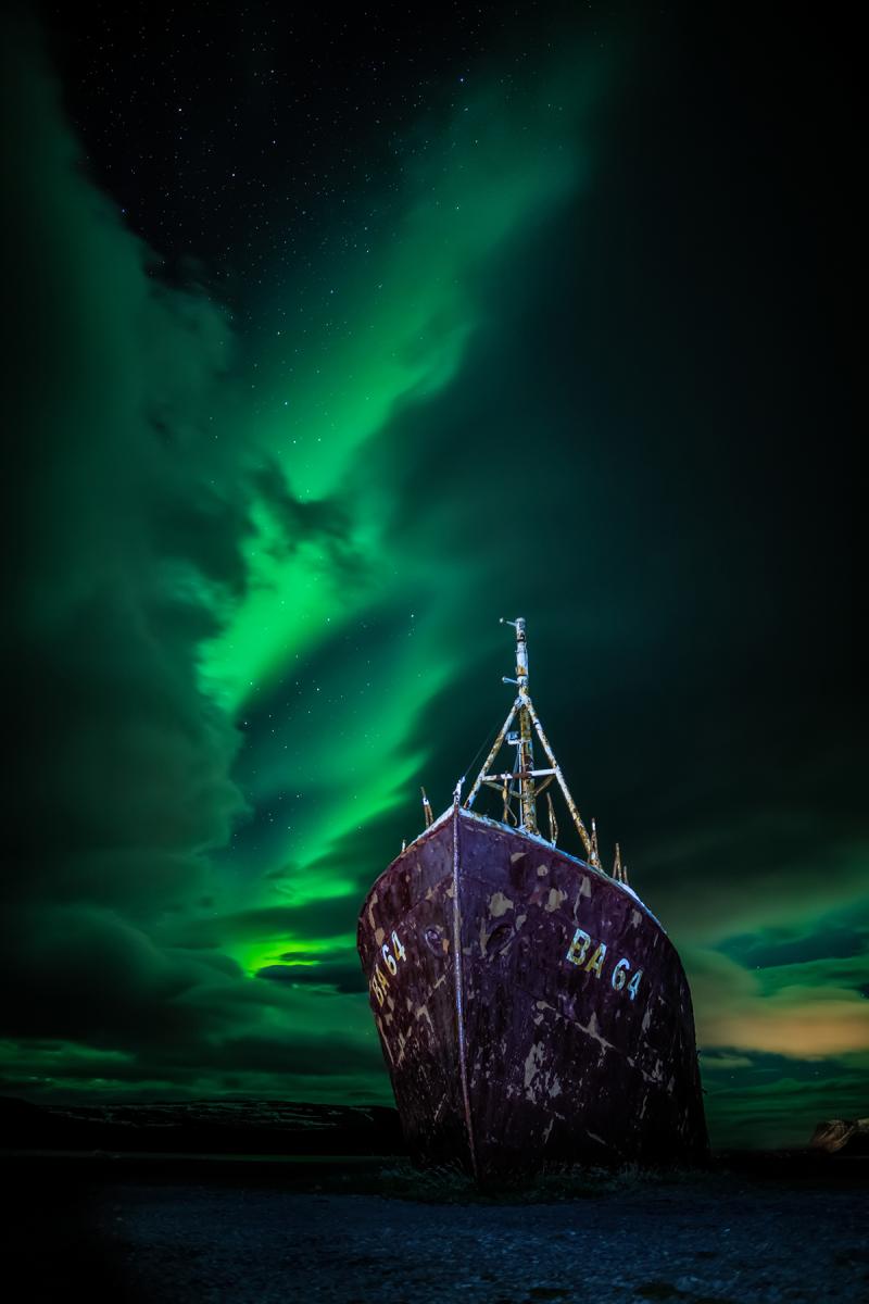 Image of a boat with aurora borealis in the background