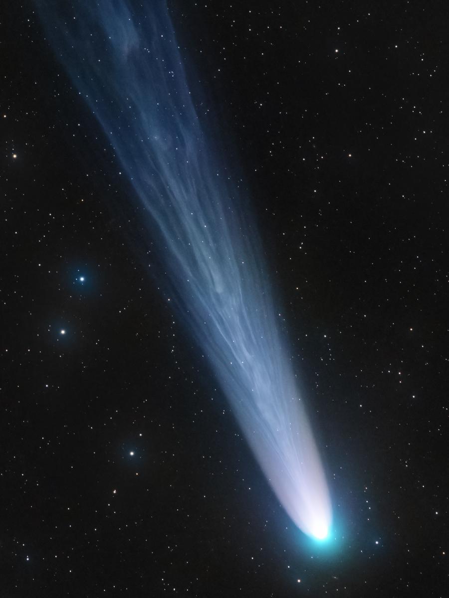 Image of Comet C/2021 with a long light blue trail