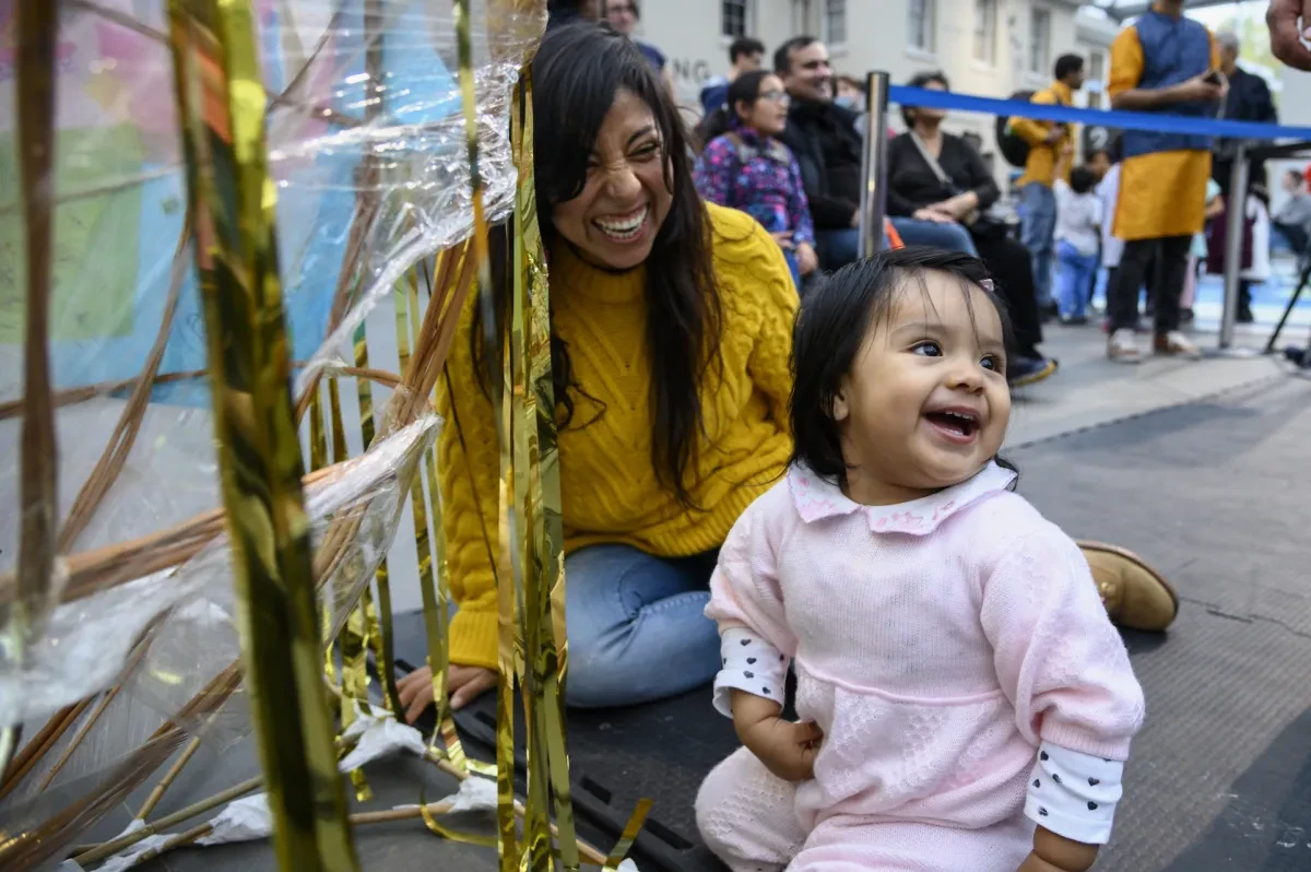 A child and her mother take part in a family activity during Diwali celebrations at the National Maritime Museum