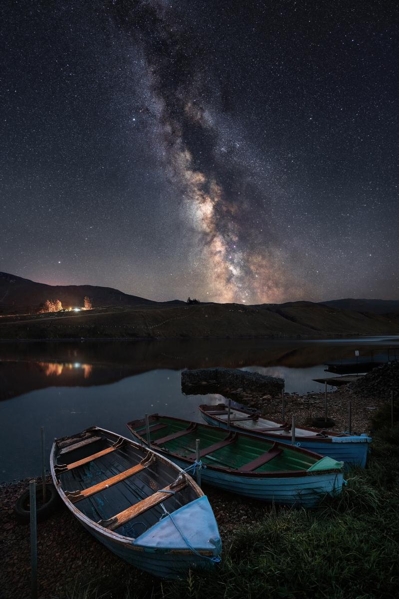 Milky Way over a lake with rowing boats