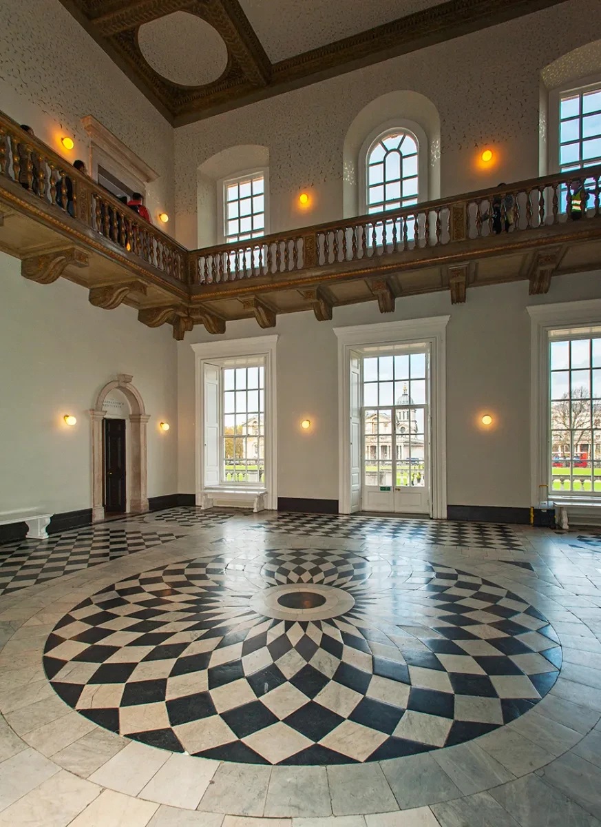 View of the Great Hall in the Queen's House, showing the distinctive black and white marble spiral pattern at the centre of the floor, and the large windows looking out towards the Old Royal Naval College and River Thames