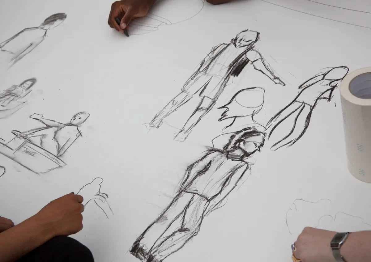 A white sheet of paper with hand-drawn sketches of people.