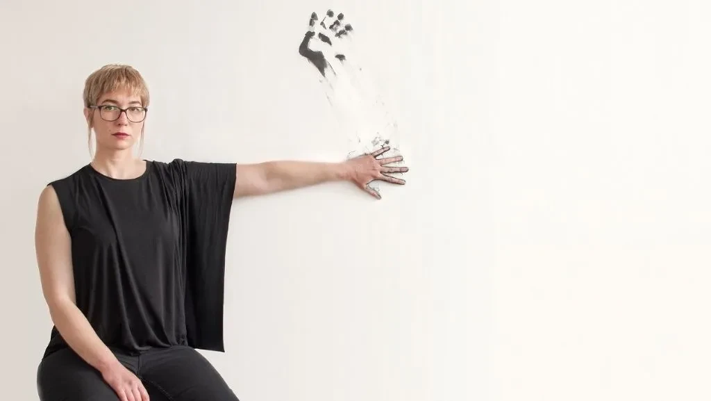 Artist making a hand print on a white wall