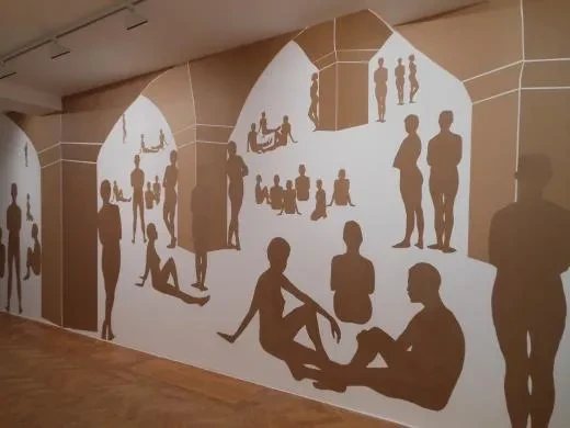 A mural showing silhouettes of people sitting and standing in groups.