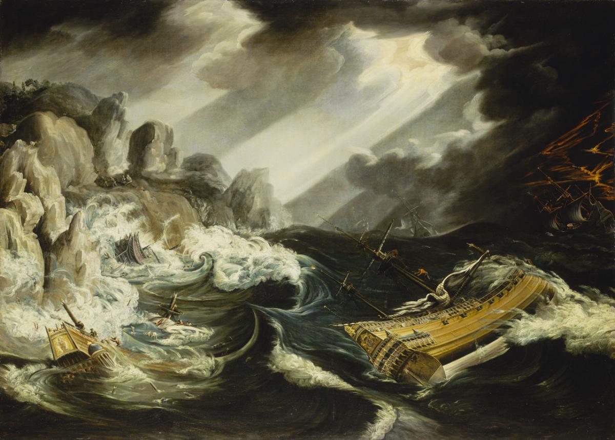 An oil painting showing a shipwreck. A tall ship is shown on its side to the right of the painting, lost in a heavy sea close to a rocky shore. Another ship can be seen smashed against the rocks to the left