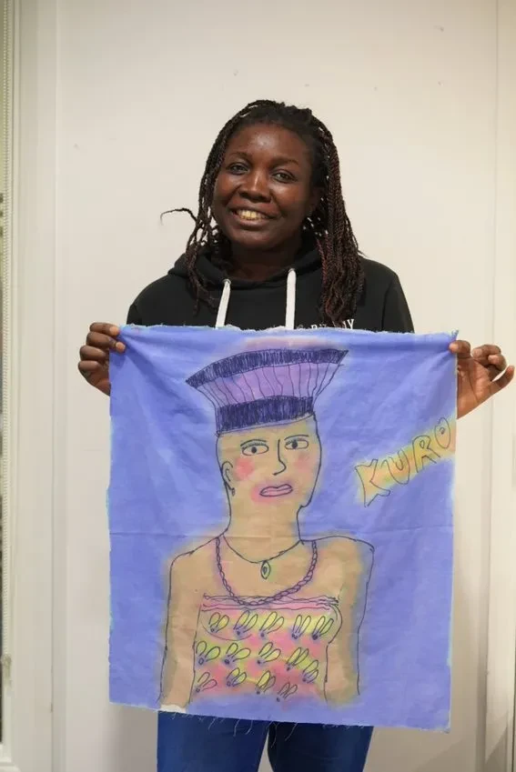 woman holding her painting of a Nigerian woman