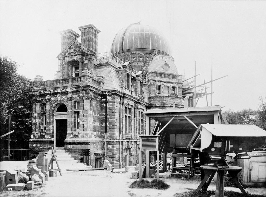 Old photograph showing Royal Observatory building halfway constructed, with brickwork missing and construction debris scattered around