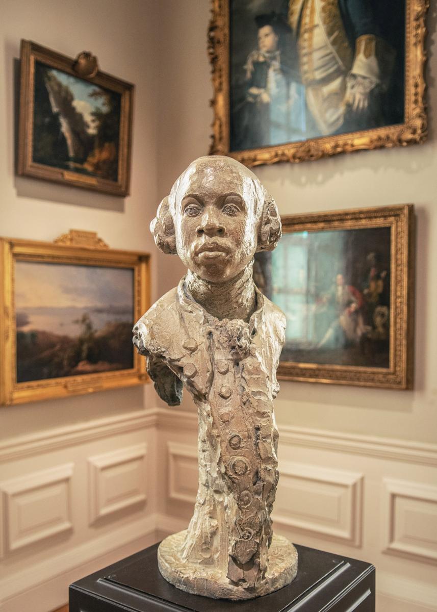 A sculpture of a man, showing only his head, shoulders and the front of his torso. Broken chains and shackles round his neck point to the man's history as a formerly enslaved person, who earned his freedom and later become an important figure in the abolitionist movement
