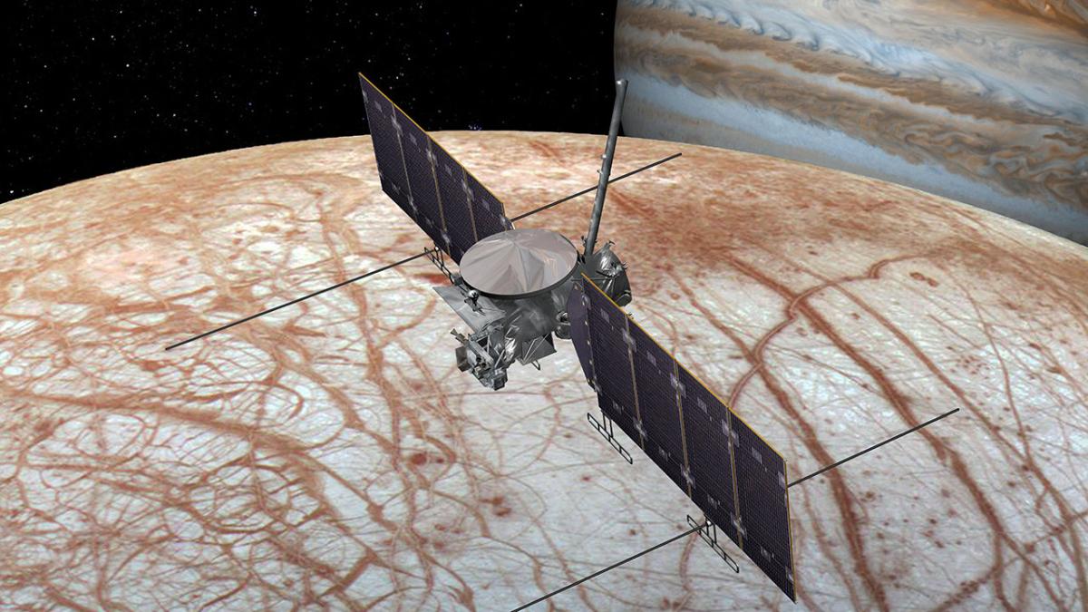Europa Clipper Illustration of spacecraft flying over moon with Jupiter behind - JUICE mission 