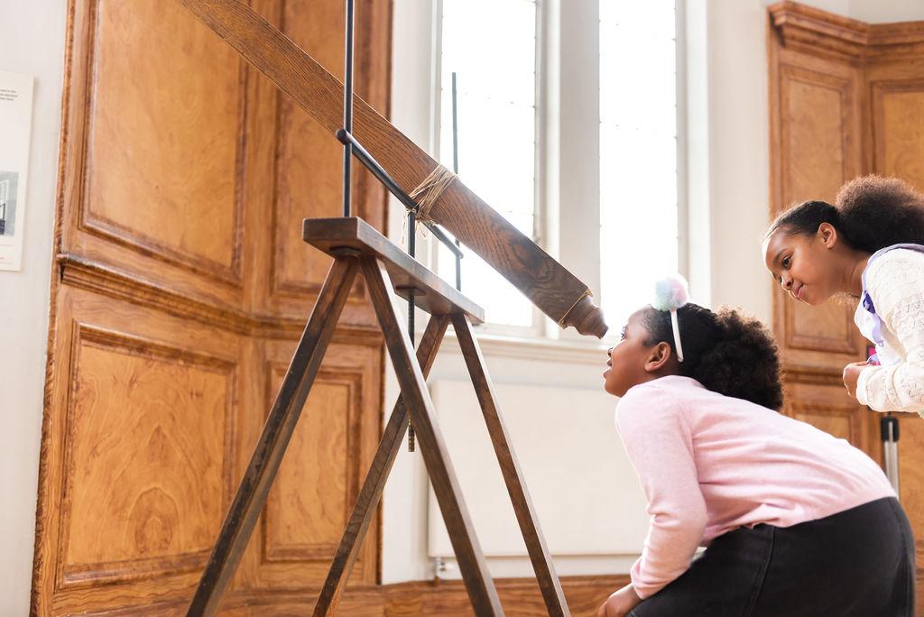 A child looks through a wooden telescope in the Royal Observatory's historic Octagon Room