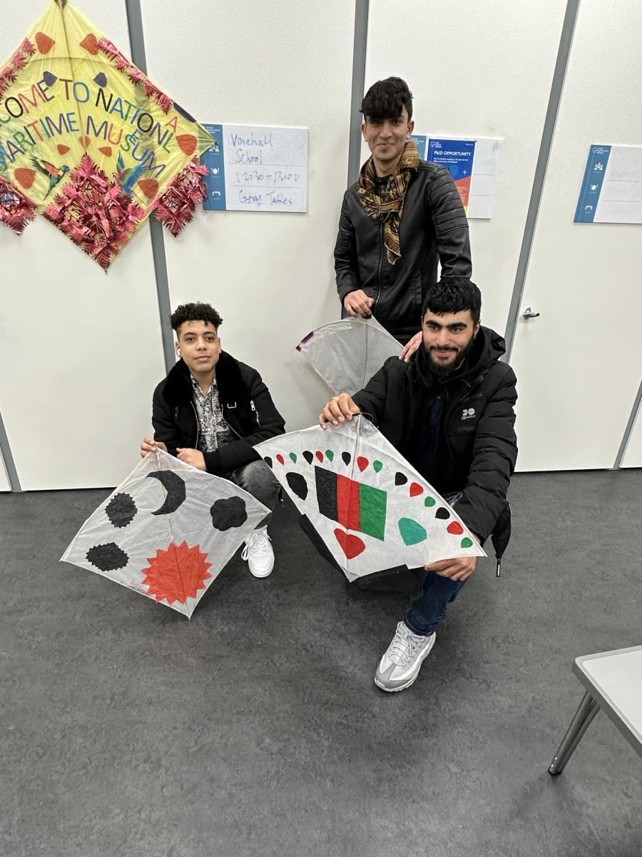 3 teenage boys holding hand-made kites