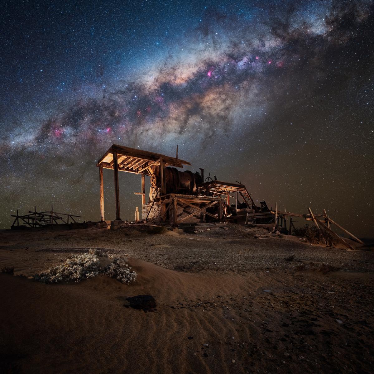Image of decayed diamond mining processing plant with the Milky Way stretching out in the sky behind it