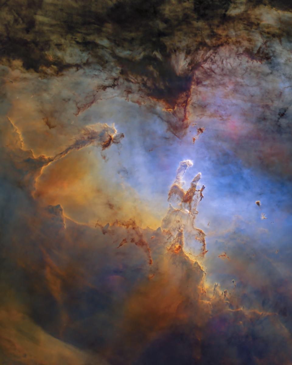 Image showing the nebula 'the pillars of creation', with clouds of gas in colours including gold and blue