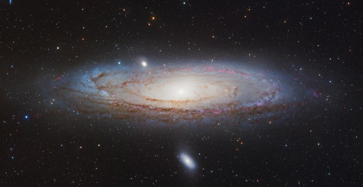 Deep space image showing the Andromeda Galaxy, a vast spiral galaxy appearing as a swirl of stars in the centre of the image