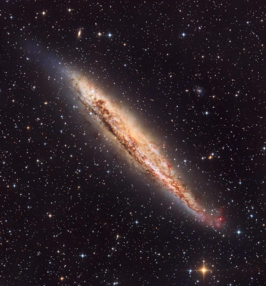 Image of a golden spiral galaxy viewed edge-on