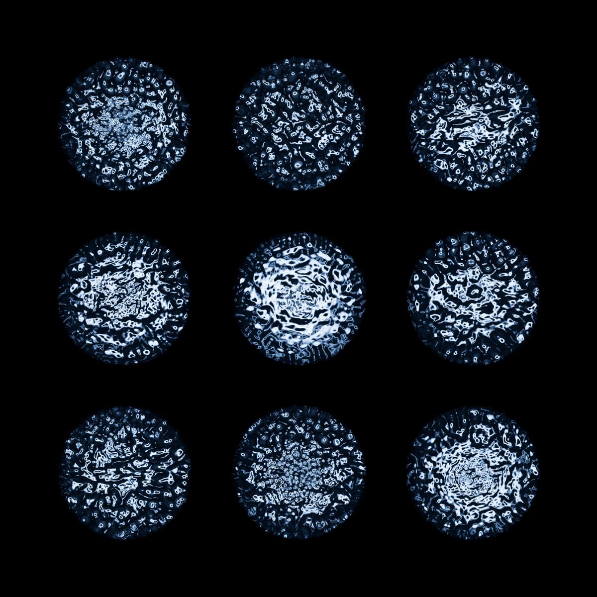Image showing black background with 9 individually spaced circles of blue water in different patters