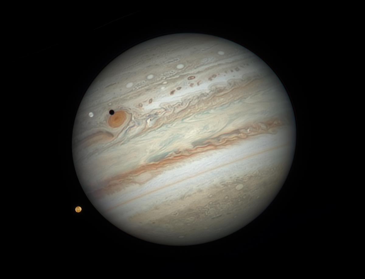 This image shows Jupiter flanked by two of its many moons (Io and Europa) under perfect conditions. A wealth of rarely seen detail is visible such as detail on the disks of the moons themselves and fine detail within Jupiter's atmosphere.
