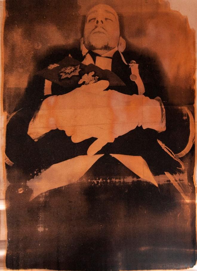 A screen print made on a copper sheet, depicting a person pretending to be a corpse in naval uniform