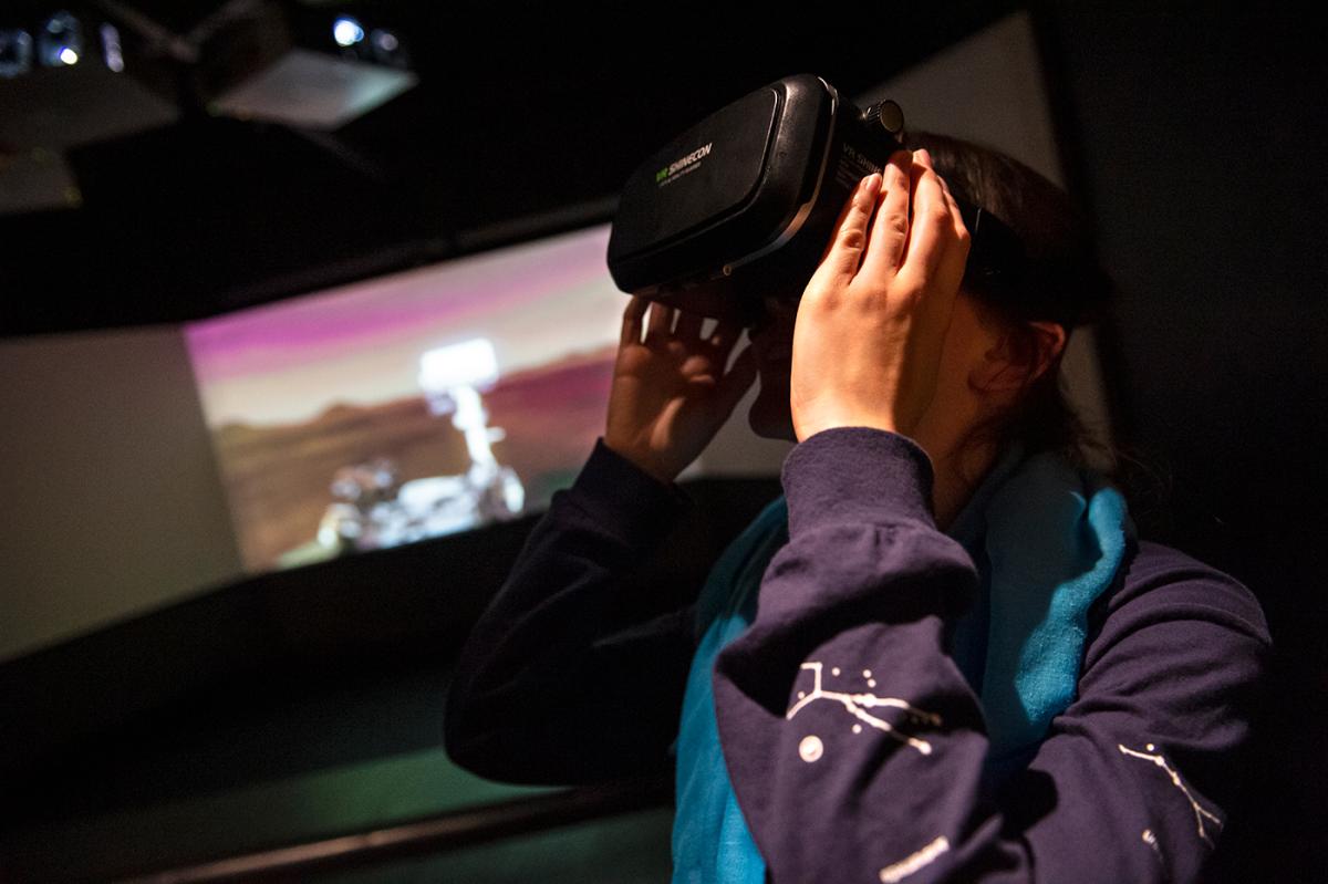 A woman looks through a VR headset