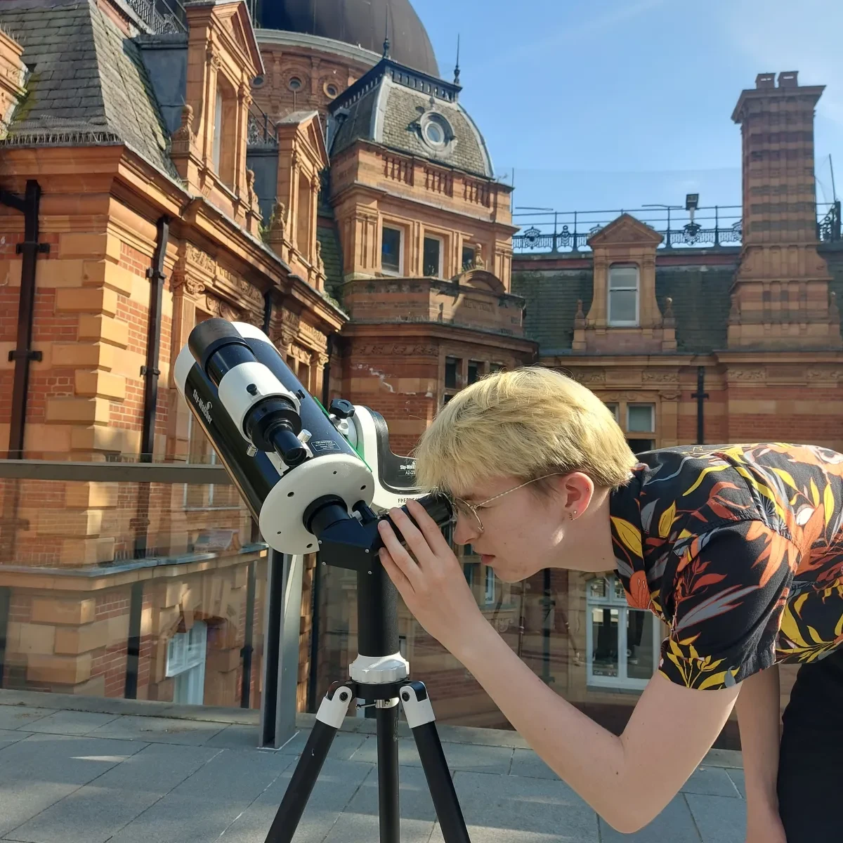 An astronomer looking through a small telescope