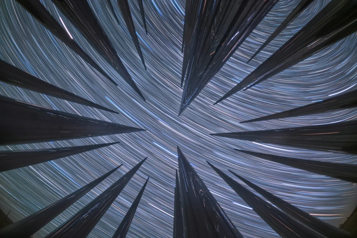 Star trails stretching above metal columns