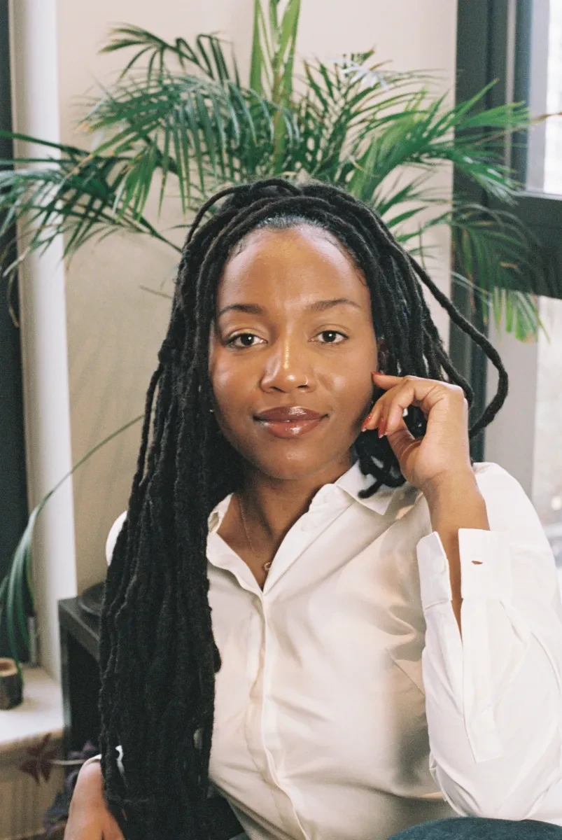 Photo of Dr Aleema Gray, who is wearing a white shirt and smiling into the camera