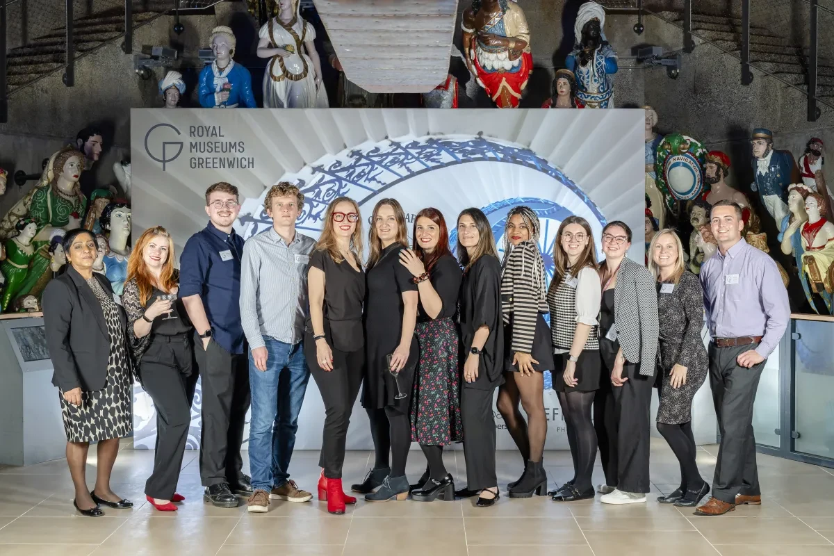 RMG showcase delivery team photo in front of custom built step & repeat board