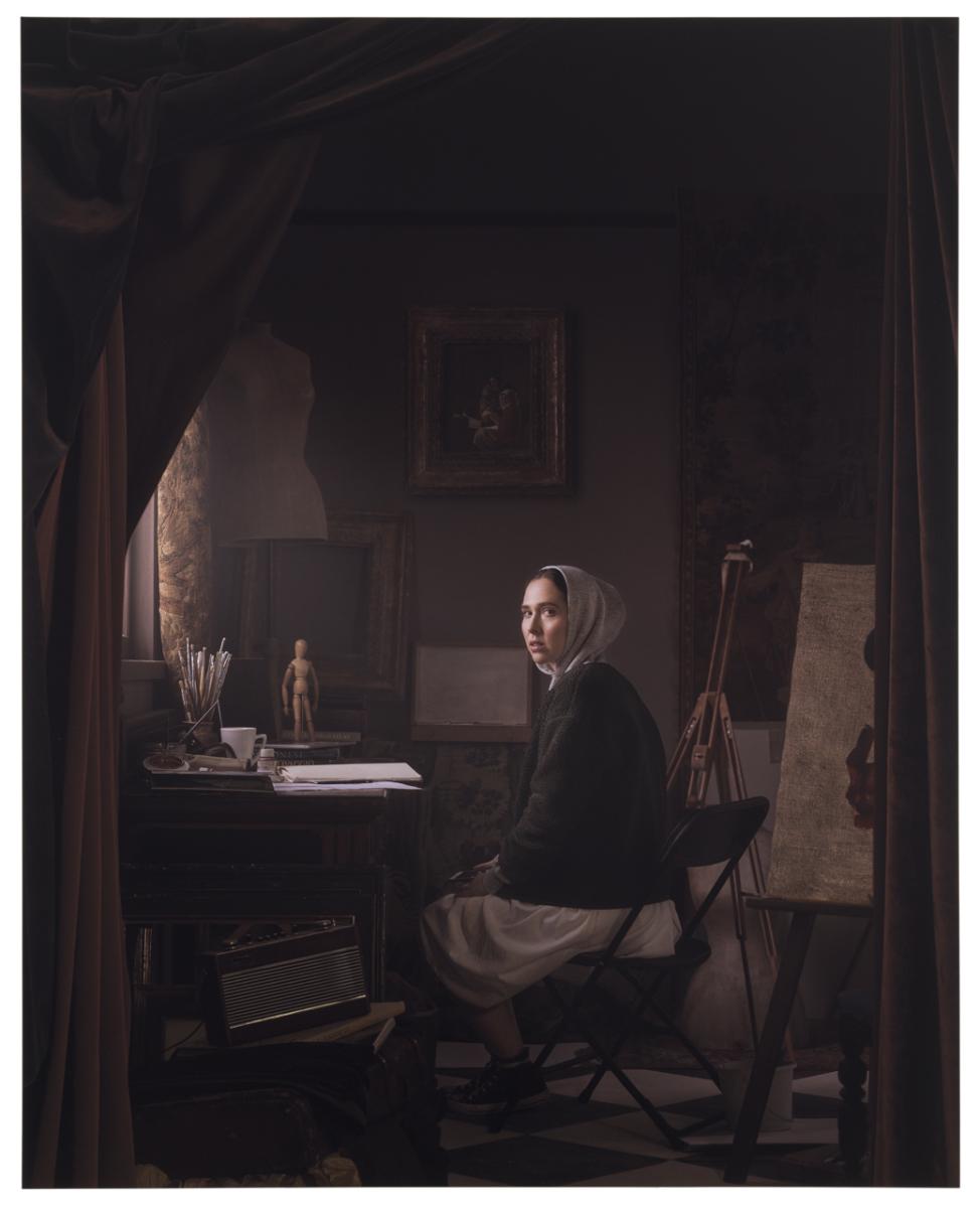 Painting of a young, 21st-century woman pictured in a pose and costume that echoes a Vermeer painting in an interior reminiscent of a 17th-century artist’s studio,