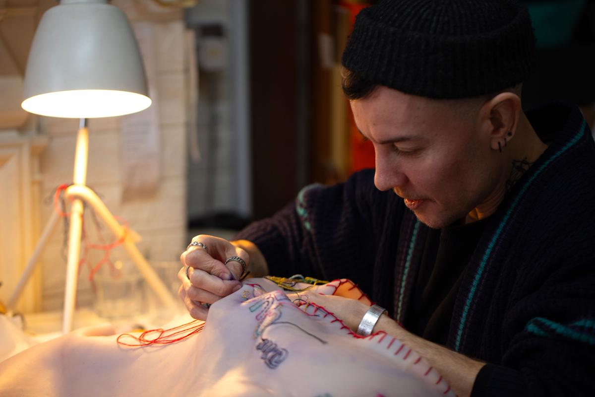 Artist EM Parry works on the 'Queering Piracy' artwork for Pirates at the National Maritime Museum, sewing 'tattoos' into a silicon body